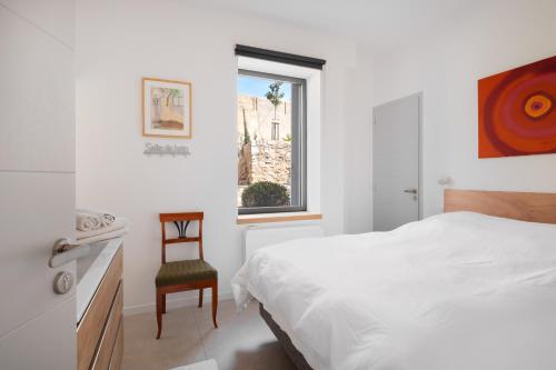 une chambre avec un lit, une chaise et une fenêtre dans l'établissement Belleza sublime Villa vue mer à Sète, à Sète