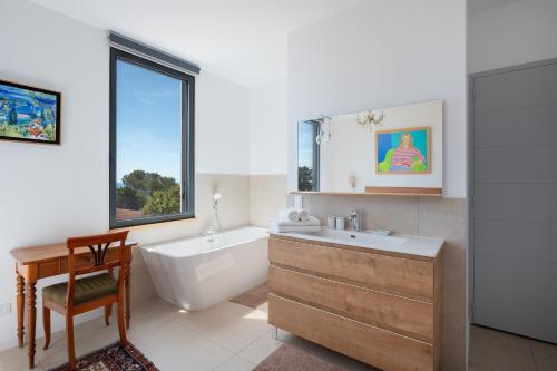 une salle de bain avec une baignoire et un lavabo et une baignoire dans l'établissement Belleza sublime Villa vue mer à Sète, à Sète