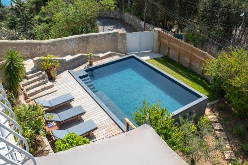 une vue aérienne d'une piscine avec quelques chaises dans l'établissement Belleza sublime Villa vue mer à Sète, à Sète