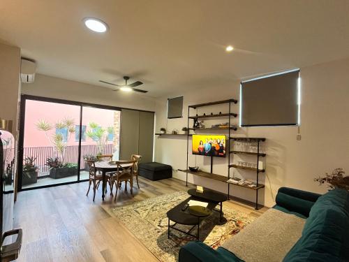 a living room with a couch and a tv and a table at Angels Loft Fremantle in Fremantle