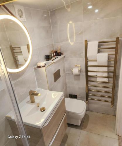 a bathroom with a sink and a toilet and a mirror at 1-Bed Studio with Parking Ideal for Couples in Newcastle upon Tyne