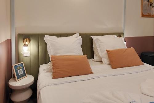 a bedroom with a bed with white and orange pillows at Aparthotel AMMI Vieux Nice in Nice