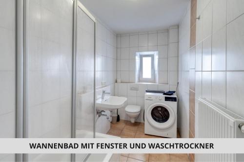a white bathroom with a washing machine and a washer at NEU Easy Sleep - FeWo mit 3 Zimmern bis 6 Personen, 5 Einzelbetten oder 2 Doppelbetten und 1 Schlafcouch, Küche, Tageslichtbad - Monteure willkommen in Bayreuth