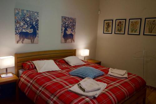 a bedroom with a red bed with two towels on it at CascinaMirta in Andorno Micca