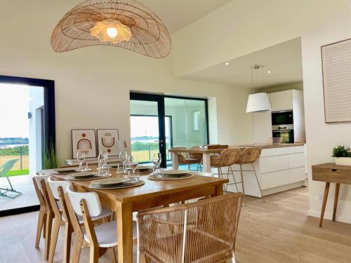 a kitchen and dining room with a table and chairs at Magnifique maison vue mer avec piscine intérieure in Carantec
