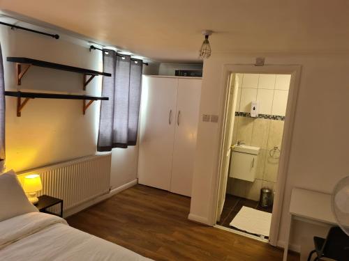 a bedroom with a bed and a door to a bathroom at 4Br-2Ensuite-10minCentralLondon-Sleeps11-Parking in London