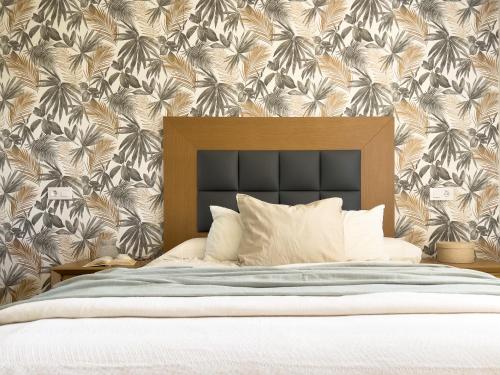 a bedroom with a bed with a tropical wallpaper at Casa Rural Villamur in Guadamur