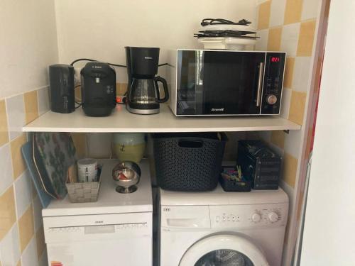 a kitchen with a microwave and a washing machine at Maison avec terrasse avec vue sur la Reculée in Les Planches-près-Arbois