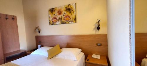 a bedroom with two beds and a painting on the wall at Hotel Mayer & Splendid - Wellness e Spa in Desenzano del Garda