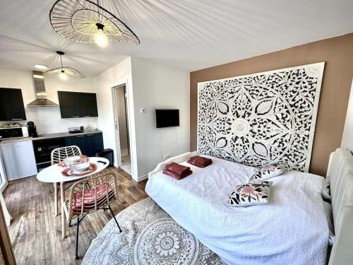 Saint-AvéにあるTy Ne Hue, Charmant Studio avec extérieur clos et Parkingのベッドとテーブルがある部屋