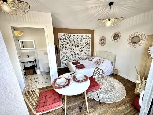 une chambre avec un lit, une table et des chaises dans l'établissement Ty Ne Hue, Charmant Studio avec extérieur clos et Parking, à Saint-Avé
