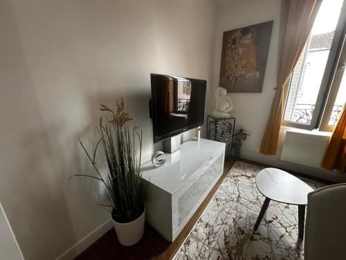 un salon avec une télévision à écran plat sur un mur dans l'établissement Appartement lumineux #612, à Malakoff