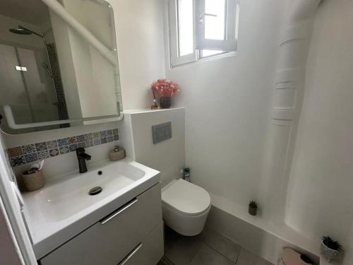 une salle de bain blanche avec des toilettes et un lavabo dans l'établissement Appartement lumineux #612, à Malakoff