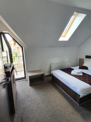a bedroom with a bed and a large window at Vila Ozon in Ranca
