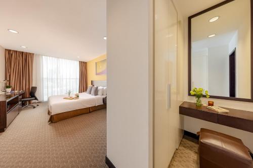 a hotel room with a bed and a mirror at Somerset Hoa Binh Hanoi in Hanoi