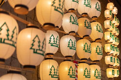 a bunch of white lanterns with trees on them at KAMENOI HOTEL Tazawako in Senboku