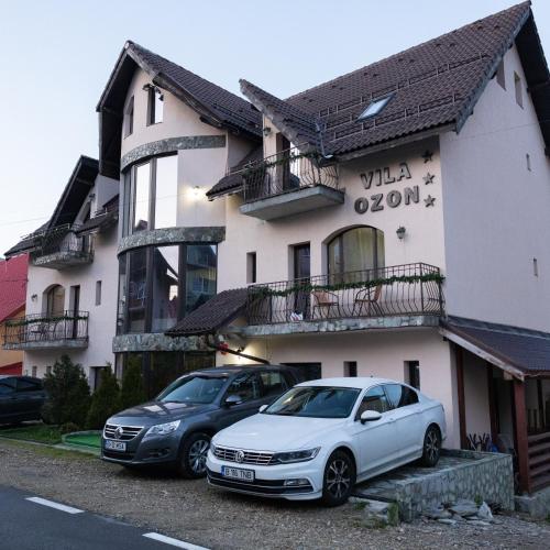 two cars parked in front of a building at Vila Ozon in Ranca