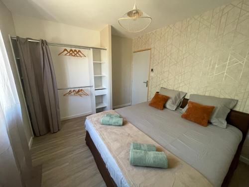 une chambre avec un grand lit avec des oreillers dessus dans l'établissement Clos des Amandiers, à Balaruc-les-Bains