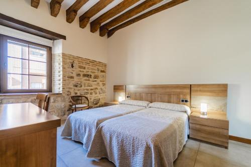 Melgar de FernamentalにあるHortelanosのベッドとテーブルと窓のある寝室