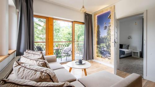 a living room with a couch and a table at Aparthotel Delta Boutique in Kościelisko