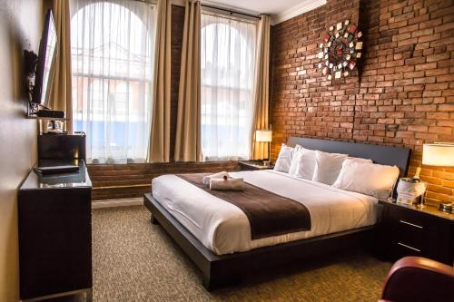 - une chambre avec un grand lit et un mur en briques dans l'établissement Century Casino & Hotel Cripple Creek, à Cripple Creek