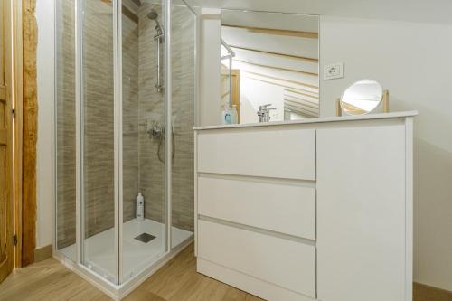 a white bathroom with a shower and a sink at Abánades in Melgar de Fernamental