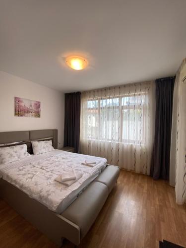 a bedroom with a large bed and a window at Къща за гости Мускат 2 in Aheloy