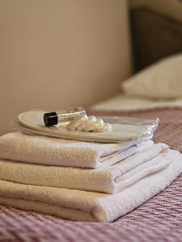 a pile of towels and a bottle of lipstick on a bed at Art Racha in Ambrolauri