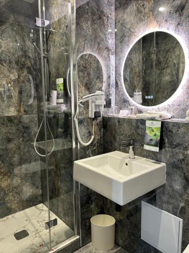 a bathroom with a sink and a shower at Sure Hotel by Best Western Reims Nord in Reims