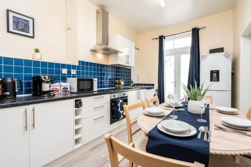 a kitchen and dining room with a table and chairs at Stunning 5 bedroom home Wirral Birkenhead Sleeps 9- Free Parking-5G Internet in Birkenhead