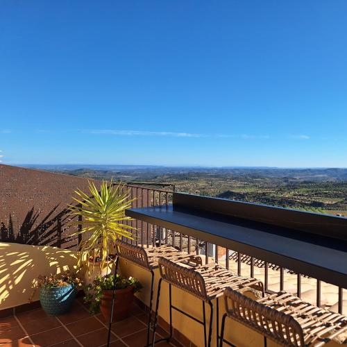 a balcony with chairs and a table with a view at Hostal Blavet in Calaceite