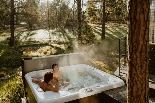 two people are in a bath tub with smoke at Stone House by Casa Oso, hot tub, 43 private acres with hiking trails in Mariposa