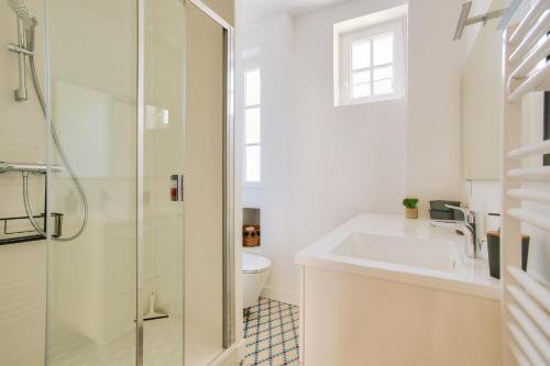 une salle de bain blanche avec un lavabo et des toilettes dans l'établissement 400m de la plage, appart pour 5 en centre-ville, à Dinard