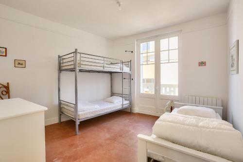 une chambre avec deux lits superposés et une fenêtre dans l'établissement 400m de la plage, appart pour 5 en centre-ville, à Dinard