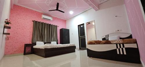 a room with two beds and a pink wall at Blue Bell Homestay in Lonavala