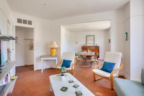 un salon avec des chaises blanches et une table dans l'établissement 400m de la plage, appart pour 5 en centre-ville, à Dinard