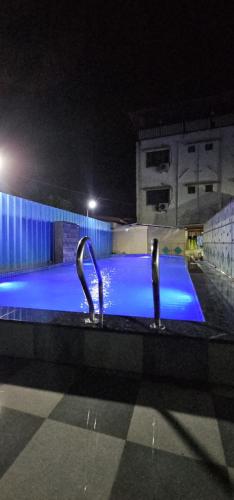 two swans in a swimming pool at night at Blue Bell Homestay in Lonavala