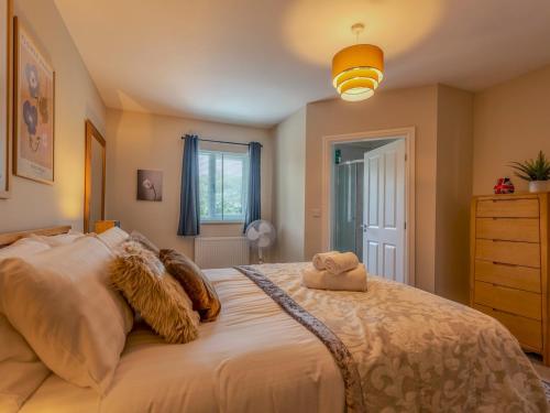 a bedroom with a large bed and a dresser at Pass the Keys Charming Modern Retreat with Private Garden in Hinstock