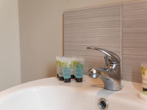 a bathroom sink with two toothbrushes and a faucet at Pass the Keys Charming Modern Retreat with Private Garden in Hinstock