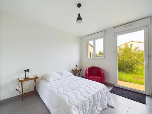 une chambre avec un lit blanc et une chaise rouge dans l'établissement À 2,7 km de la plage, maison au calme pour 6, à Les Sables-dʼOlonne