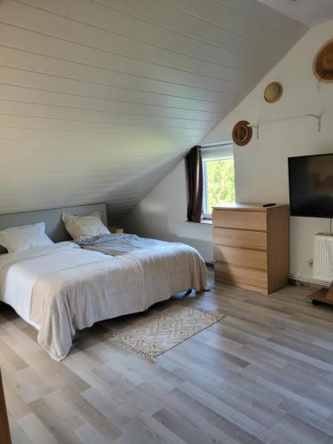 una camera da letto con un letto e una TV a schermo piatto di La Maison des Roses a Francorchamps