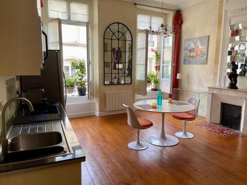 - une cuisine avec une table et deux chaises dans une pièce dans l'établissement Au coeur de Bordeaux, à Bordeaux