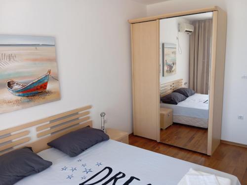 ein Schlafzimmer mit zwei Betten und einem Spiegel in der Unterkunft Victoria's apartments -Marina Cape - Aheloy in Aheloy