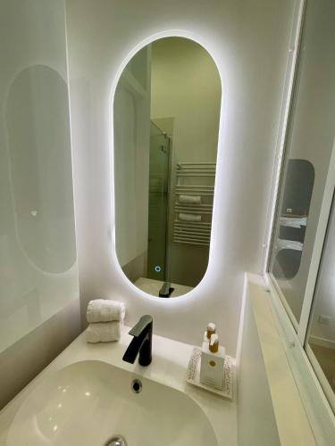 une salle de bain blanche avec un lavabo et un miroir dans l'établissement Au coeur de Bordeaux, à Bordeaux