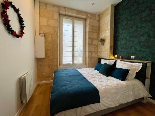 une chambre avec un grand lit avec une couverture bleue dans l'établissement Au coeur de Bordeaux, à Bordeaux
