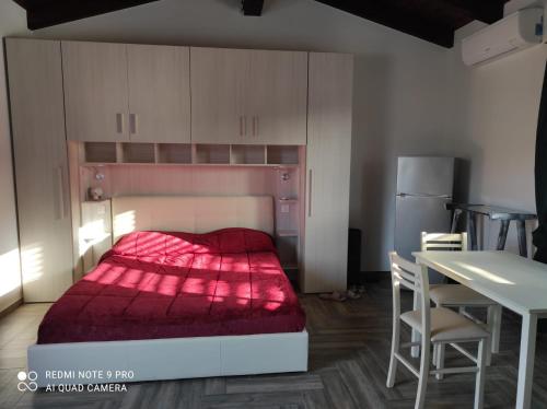 a small bedroom with a bed with a red blanket at Villa Erilia in San Giovanni Suèrgiu
