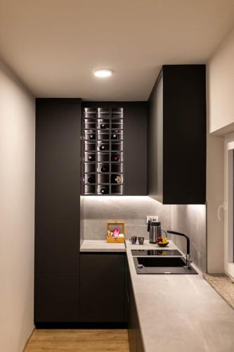 a kitchen with black cabinets and a sink at Casa Cordis in Korduševci