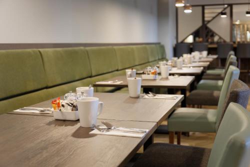 a row of tables and chairs in a restaurant at Holiday Inn South Normanton M1, Jct.28 by IHG in South Normanton