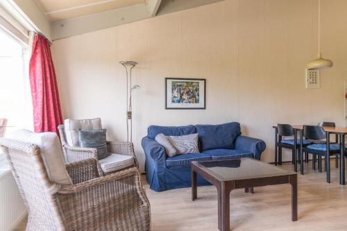 a living room with a blue couch and chairs at Beach appartement 40 in Callantsoog