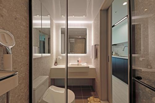 a bathroom with a toilet and a sink at Elmomento Songdo in Busan
